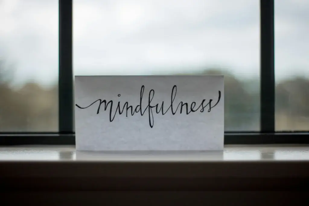 a paper where the word mindfulness is written standing before the window