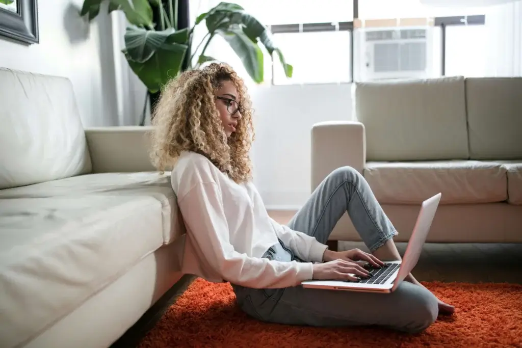 a woman is sitting on the floor with a laptop trying to find work-life balance
