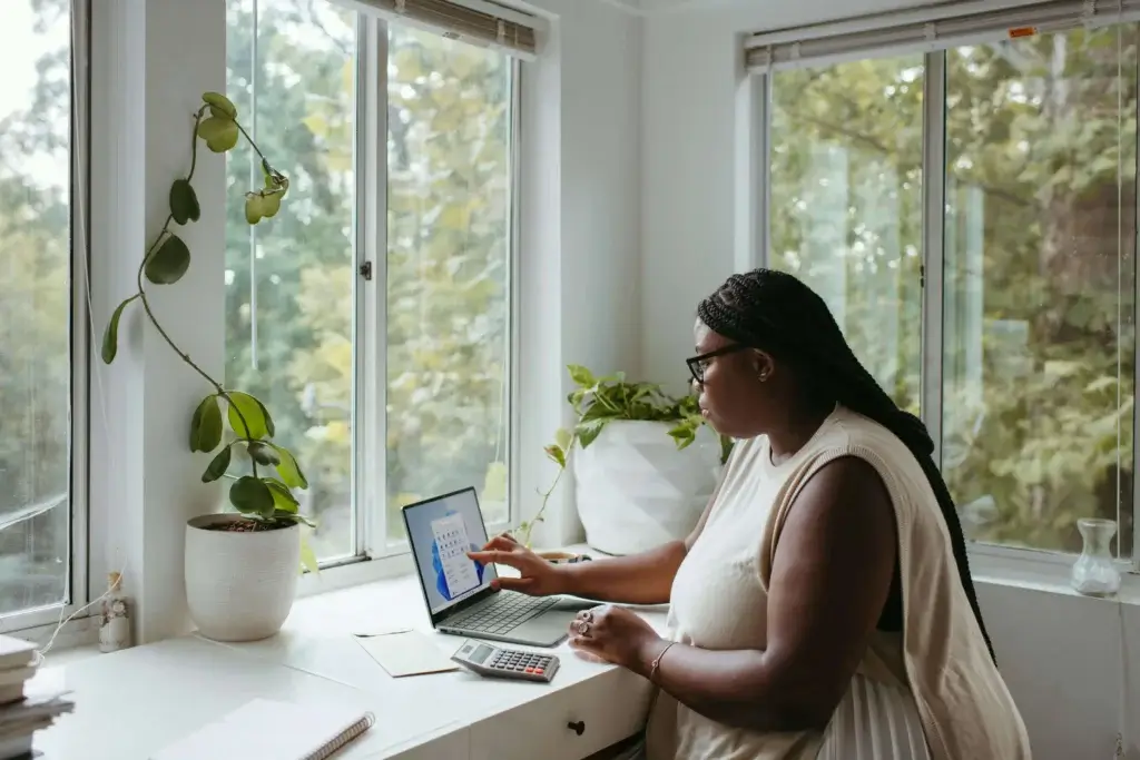 a woman is working remotely on her laptop with a view on a nature