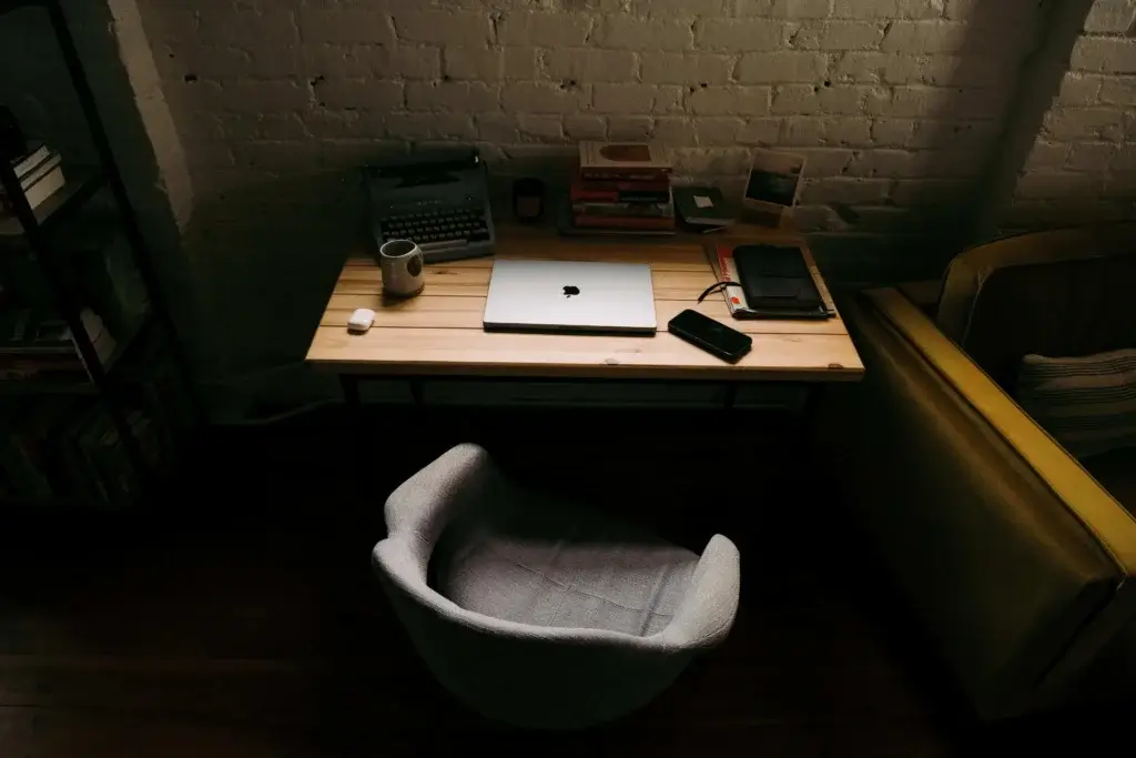 remote workplace with a laptop standing on the desk along with coffee, phone and tablet