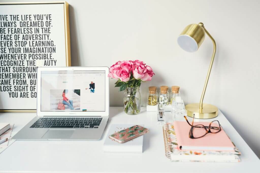 A stylish and organized workspace with a laptop, notebooks, and flowers, representing productivity and work-life balance statistics.