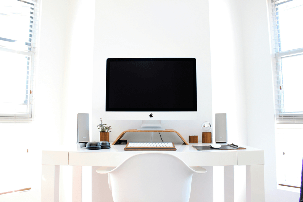 White Compact Desk with a computer, speakers, keyword, mouse and other accessories