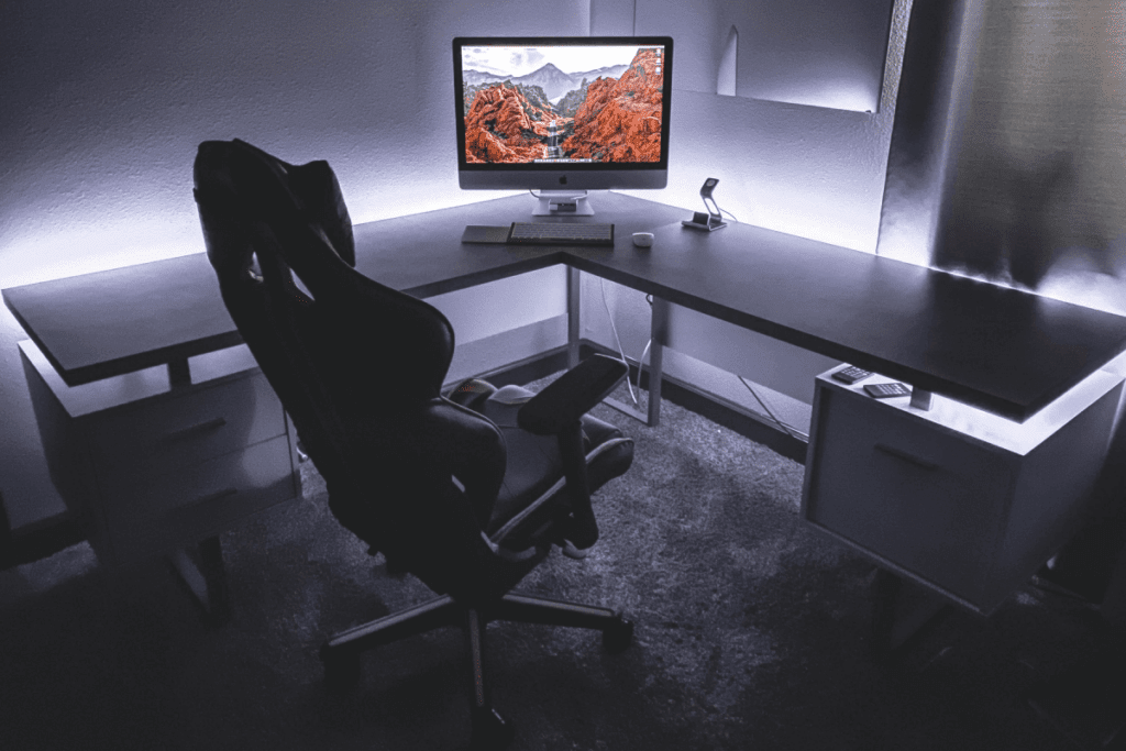 Black L-Shaped Home Desk with a computer and accessories