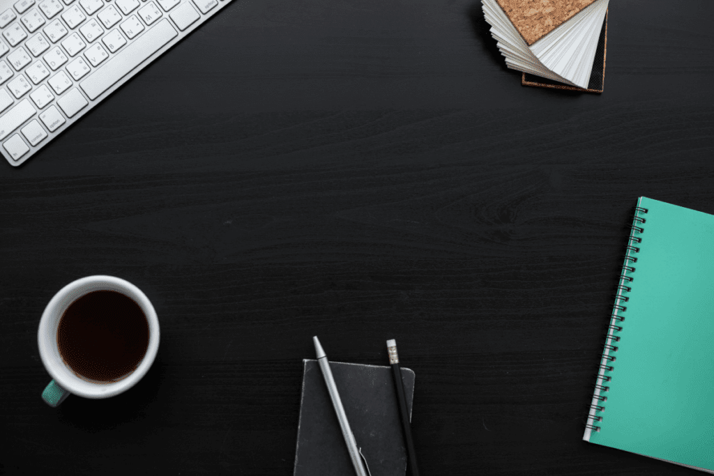 Black Laminate Office Desk with a cup of coffee, keyboard and notepad