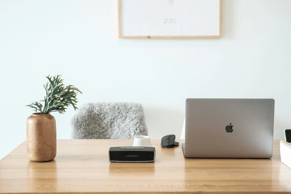 Sleek and modern home desk with a MacBook and stylish decor.