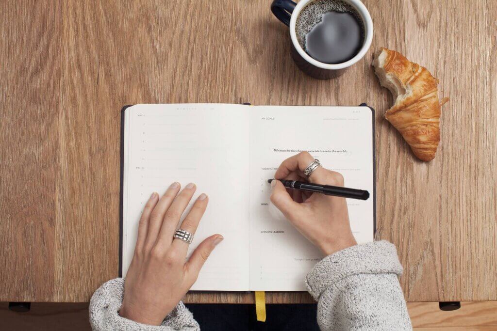 a person is writing something in her notebook