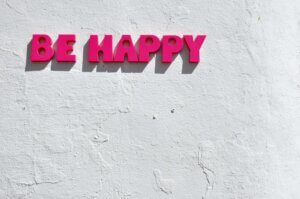 a sign on the wall which says Be Happy