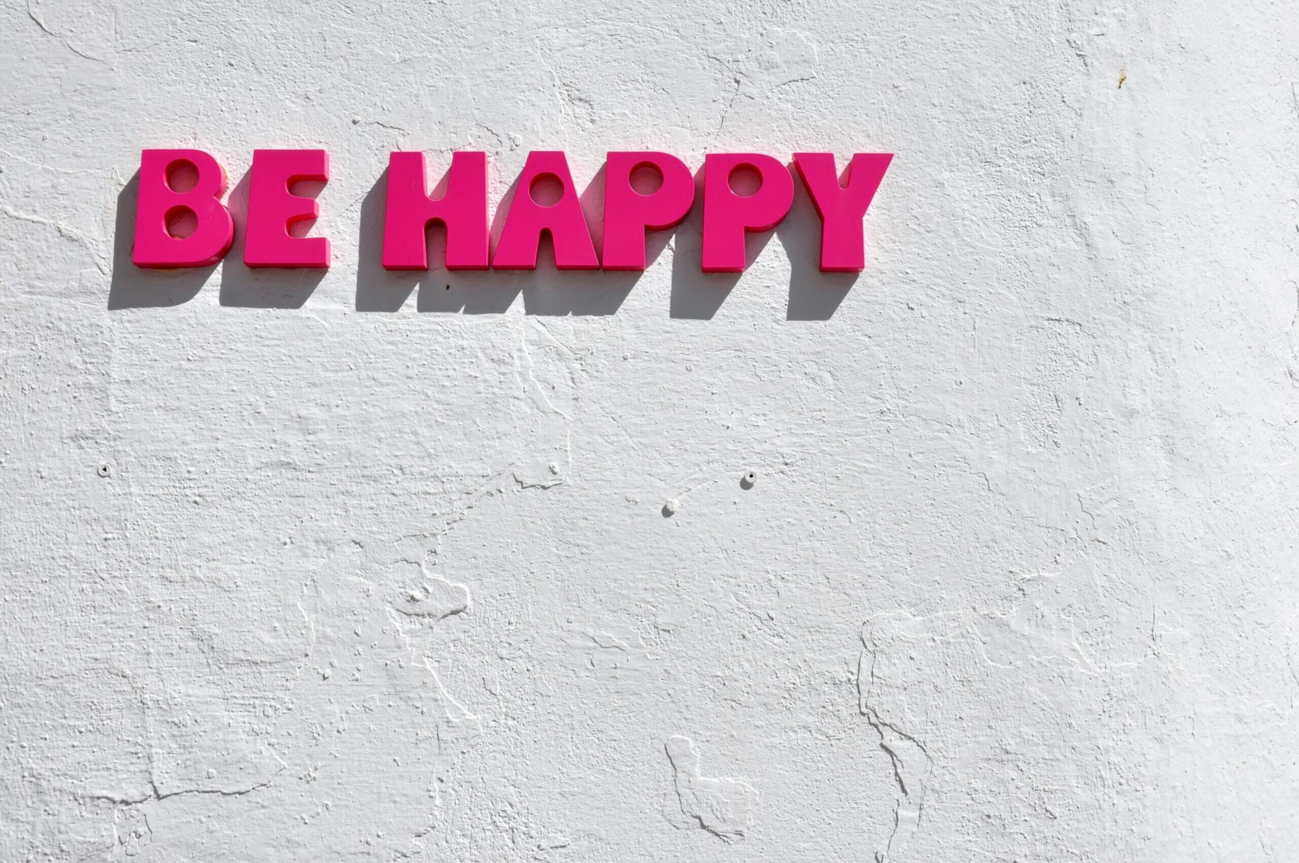 a sign on the wall which says Be Happy