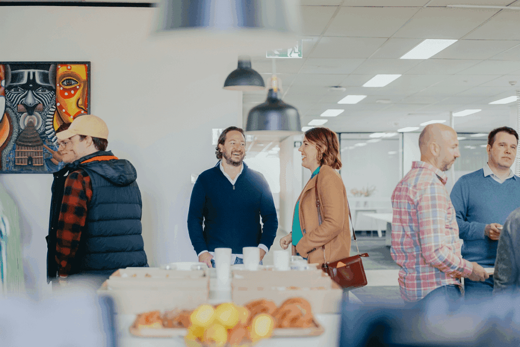 Professionals engaging in conversation at a networking event demonstrating how to network with people in an office setting