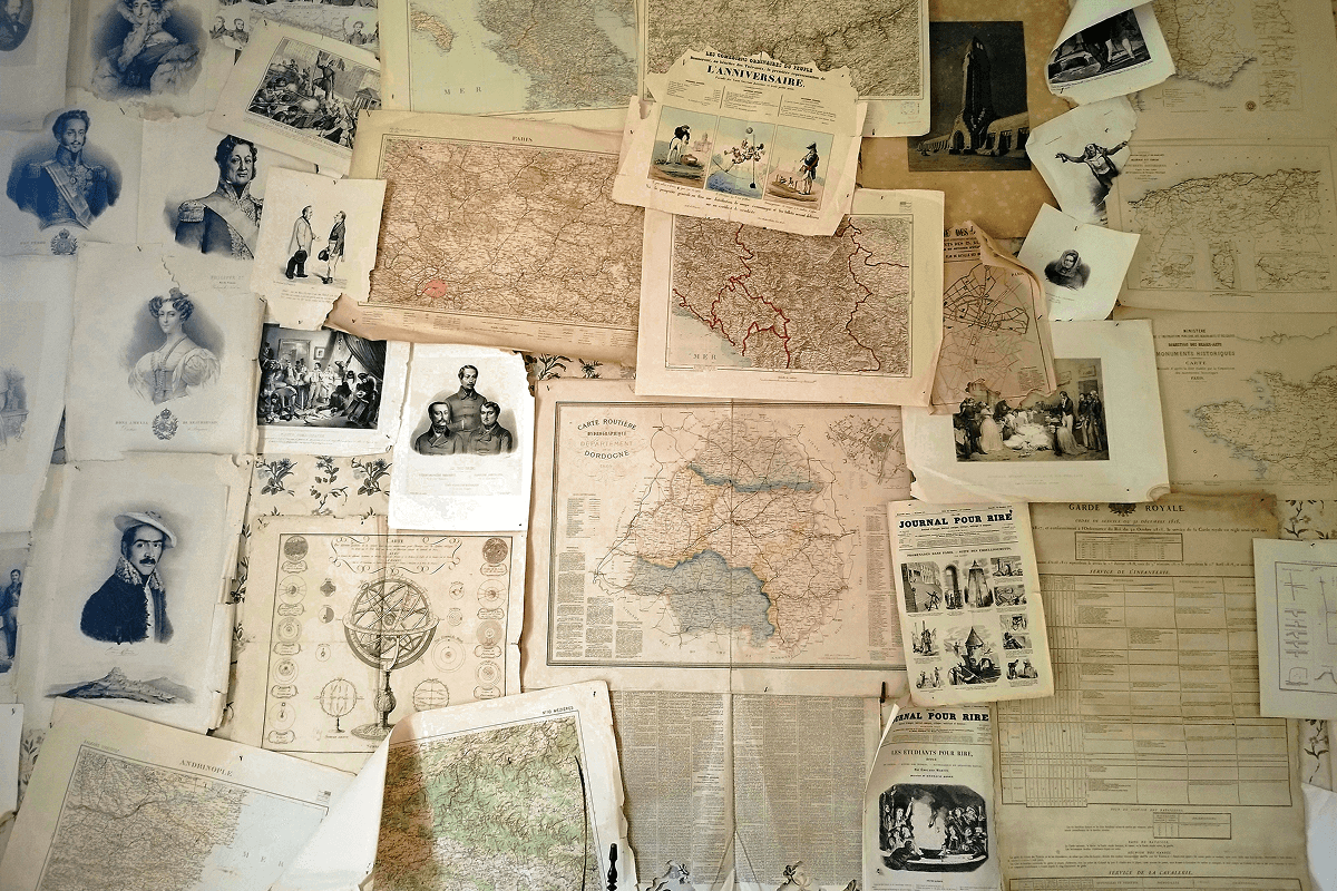 A collage of vintage maps, portraits, and newspapers pinned to a wall, offering resources for how to become a genealogist.